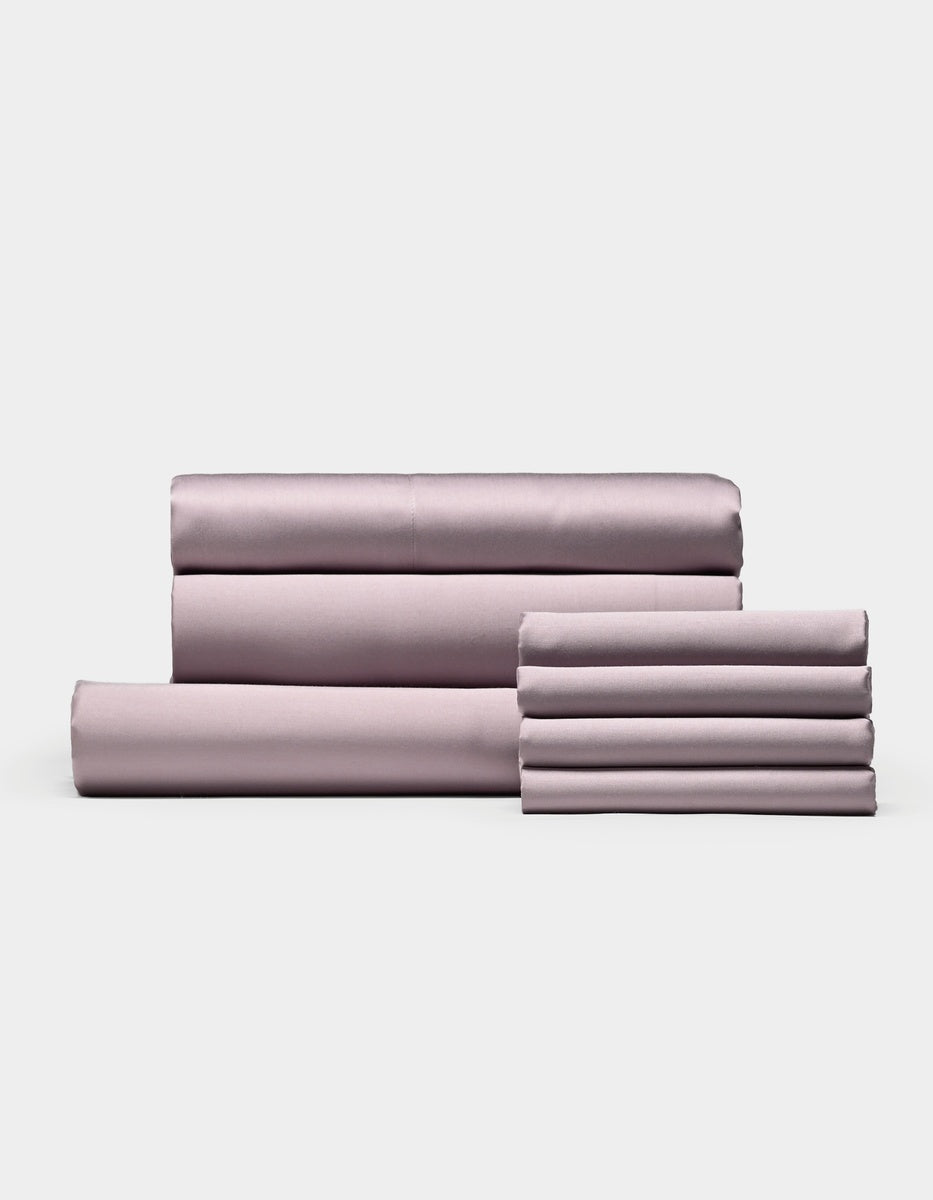 A neatly folded set of Cozy Earth Bamboo Bedding Core Bundle sheets and pillowcases, including both flat and fitted sheets, arranged against a plain white background.|Color:Lavender