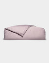 A neatly folded Cozy Earth Bamboo Duvet Cover in lavender, with one corner turned back, displayed against a plain white background.|Color:Lavender