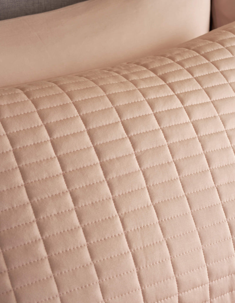 Close-up of Cozy Earth Bamboo Jersey Quilted Shams, showing a beige quilted fabric with a grid pattern of stitched lines. The texture and stitching of this soft, elegant sham are clearly visible.