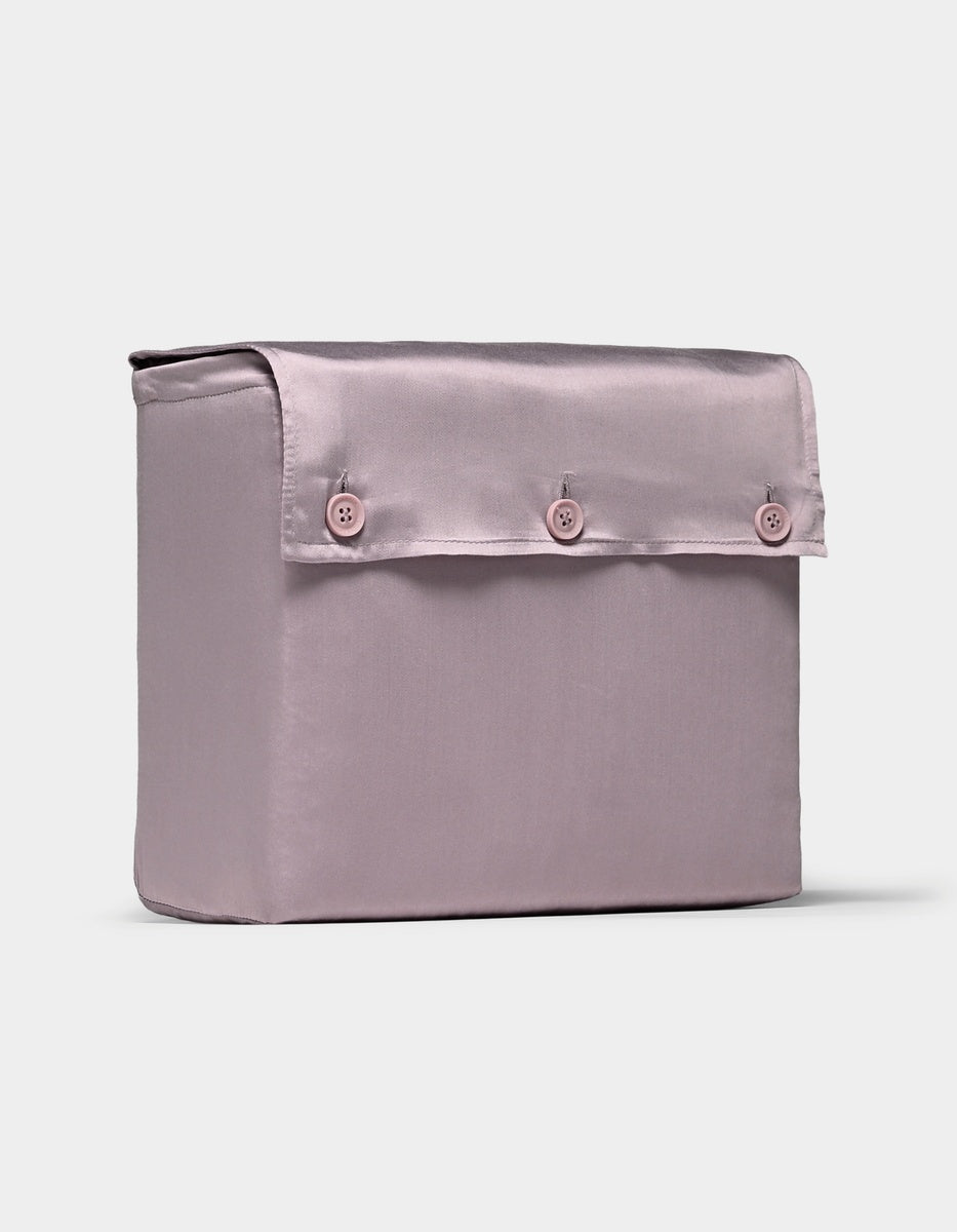A luxurious, light purple bamboo sheet set from Cozy Earth featuring a smooth satin finish and presented in a rectangular fabric storage box with a flap cover secured by three matching buttons on the front.