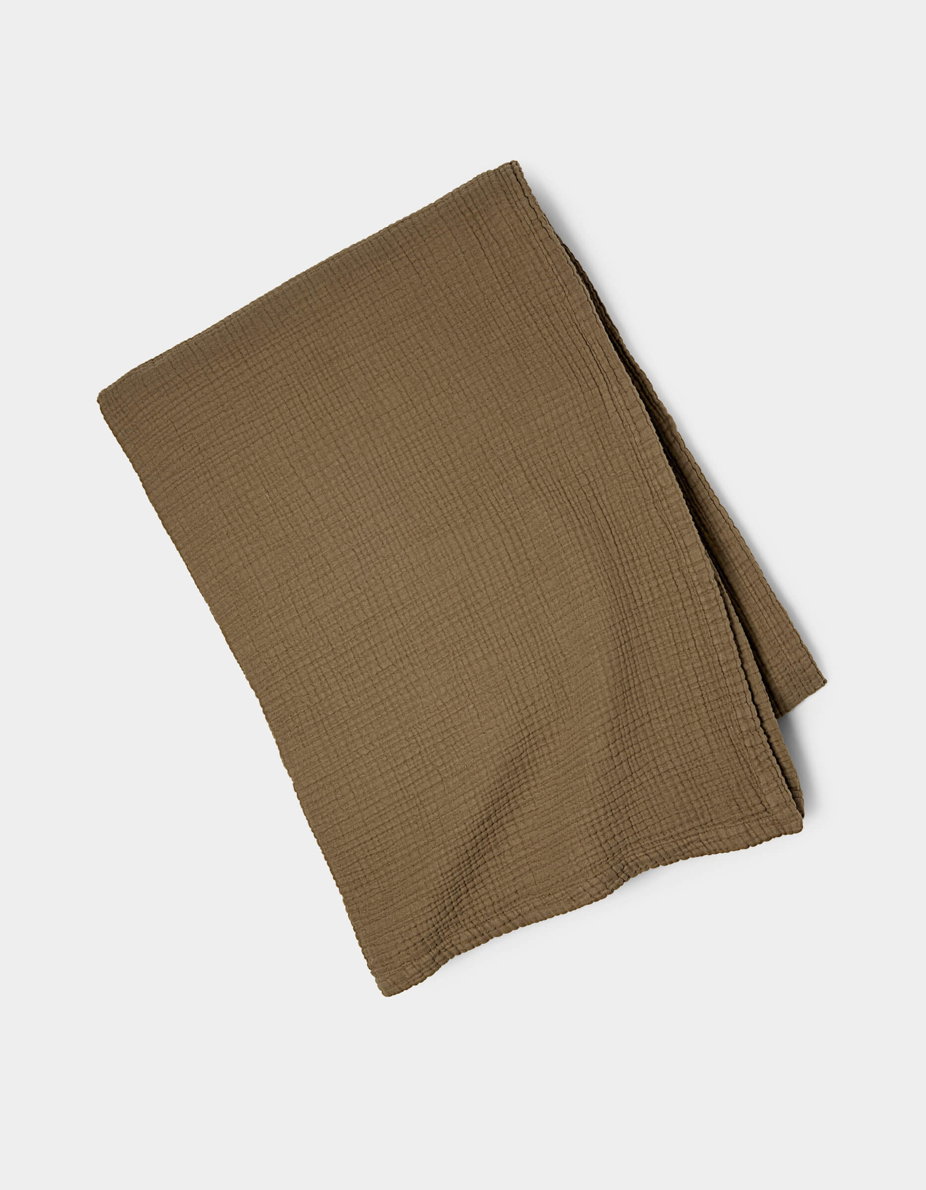 The Cozy Earth Cotton Gauze Blanket, featuring a textured brown fabric, is shown neatly folded on a plain white background.