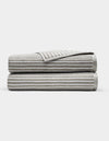 Two Cozy Earth Ribbed Terry Bath Sheets in gray and white stripes are folded and stacked on each other against a plain white background.|Color:Dew Stripe