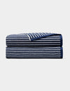 A Cozy Earth Ribbed Terry Bath Sheet in navy blue with horizontal white stripes, neatly folded and stacked on a plain light background.|Color:Obsidian Stripe