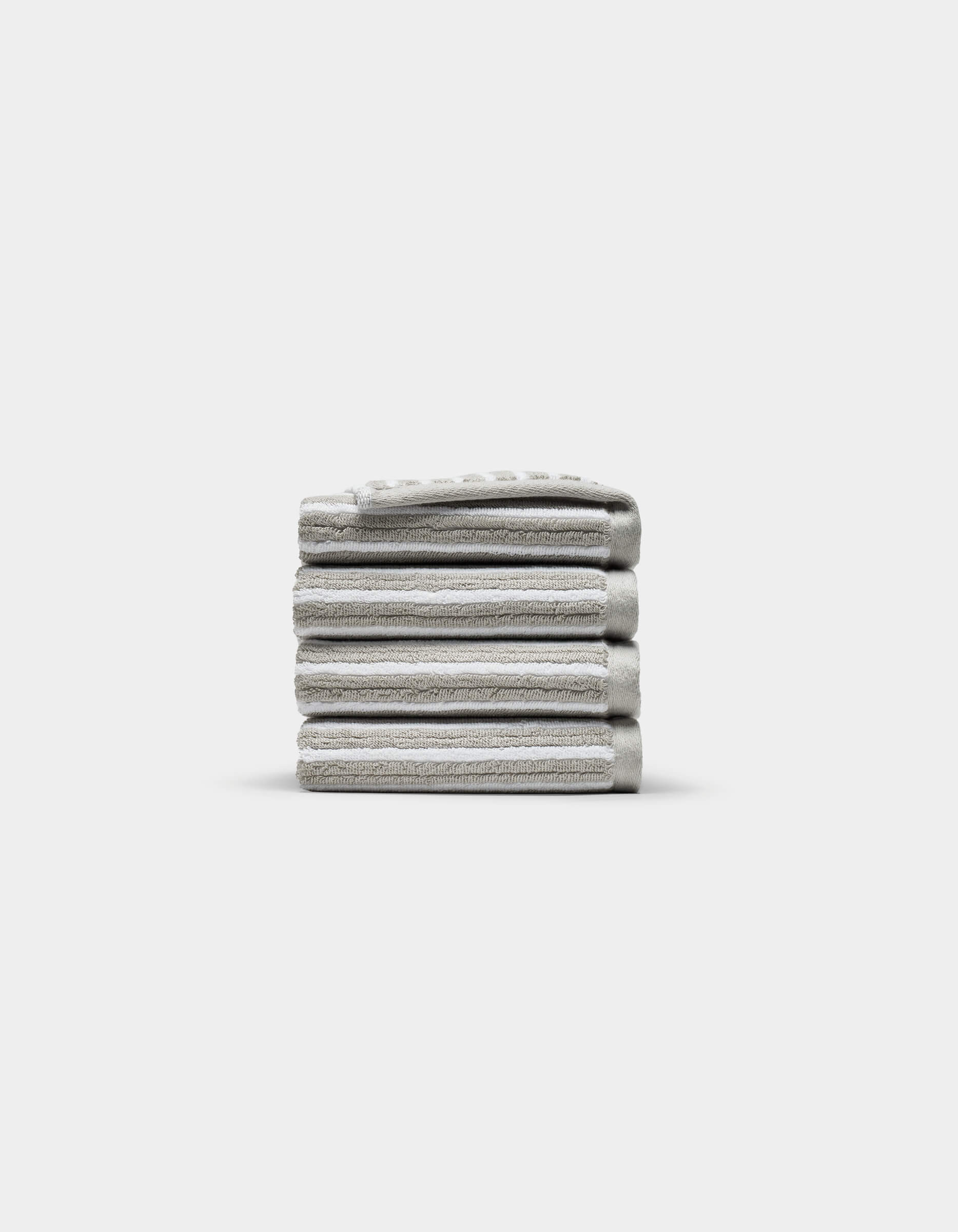 A neatly stacked pile of five folded light gray Ribbed Terry Washcloths by Cozy Earth is centered on a plain white background.