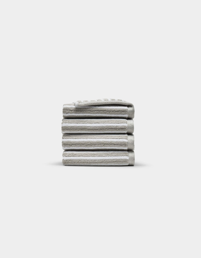 A neatly stacked pile of five folded light gray Ribbed Terry Washcloths by Cozy Earth is centered on a plain white background.