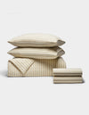 The Cozy Earth Soft-Wash Cotton Bedding Deluxe Bundle, featuring two pillows, a folded duvet, and two folded sheets in beige and white stripes, is neatly arranged against a plain white background.|Color:Coconut and Sandalwood Stripe