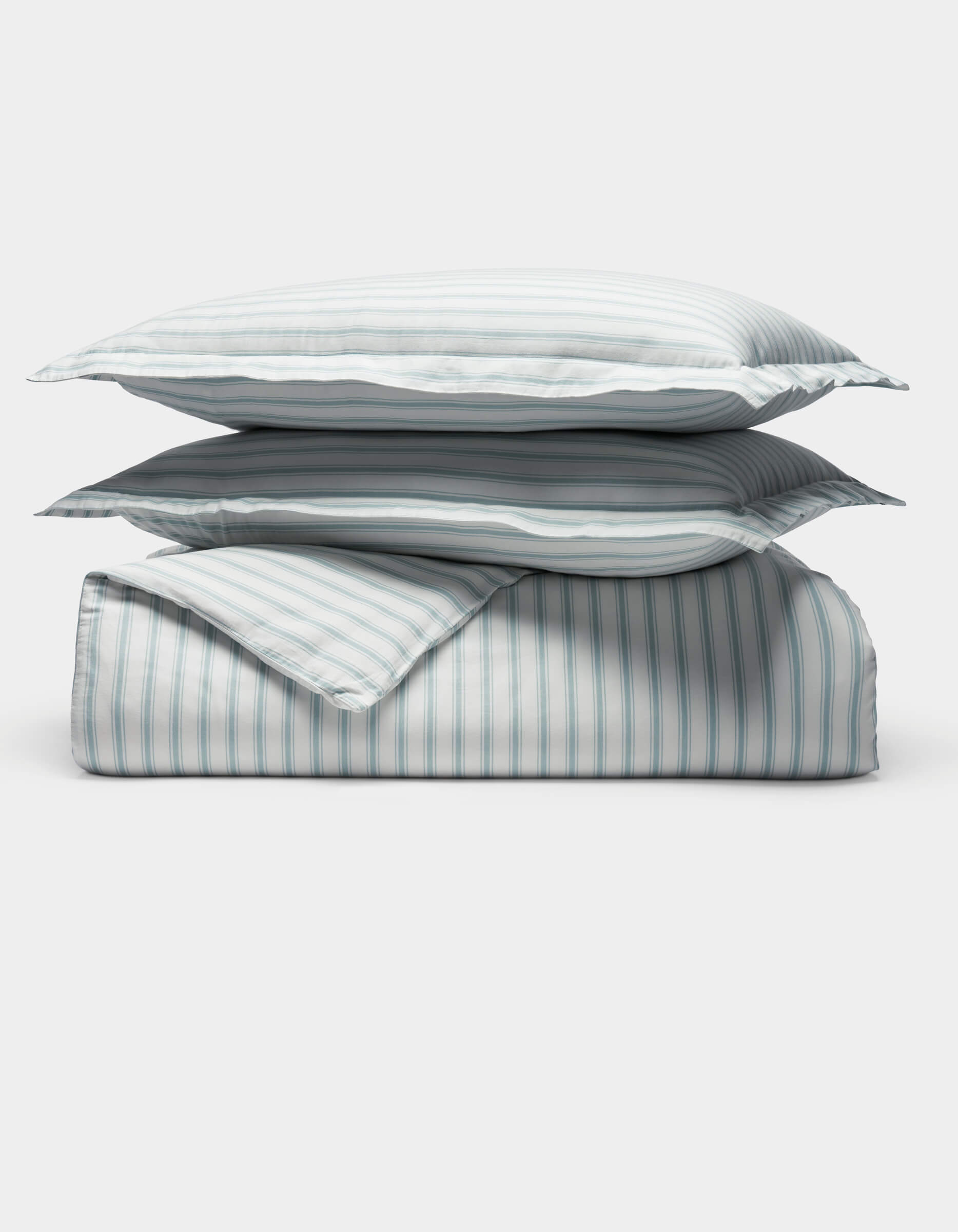 The Cozy Earth Soft-Wash Cotton Duvet Set is displayed neatly folded with two stacked pillows and a comforter, all in a light blue and white vertical striped pattern, set against a plain white background.|Color:River and Sea Salt Stripe
