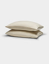Two Cozy Earth Soft-Wash Cotton Pillowcases in beige with thin horizontal brown stripes are stacked against a plain white background.|Color:Coconut and Sandalwood Stripe
