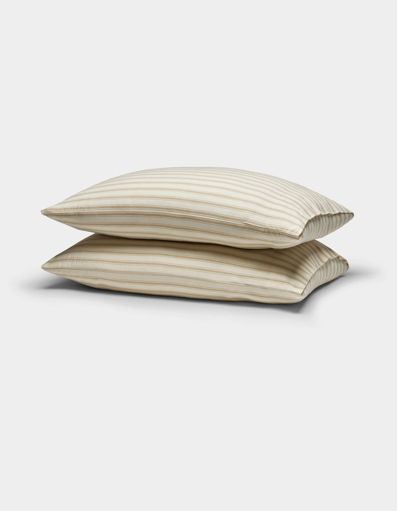 Two Cozy Earth Soft-Wash Cotton Pillowcases in beige with thin horizontal brown stripes are stacked against a plain white background.