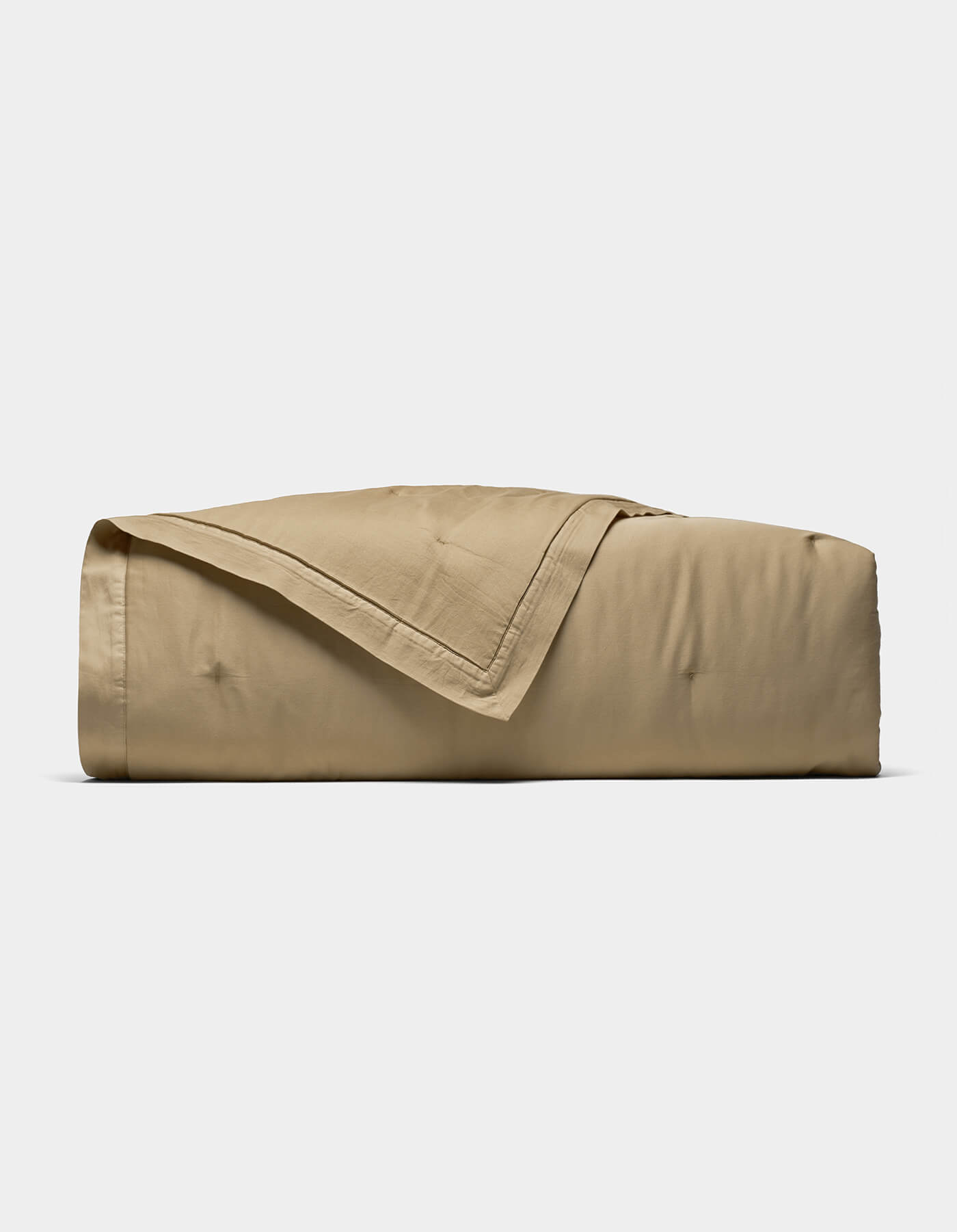 The Cozy Earth Soft-Wash Cotton Quilt, in light brown, is neatly folded with one corner draped over the top and displayed on a plain white background.|Color:Sandalwood
