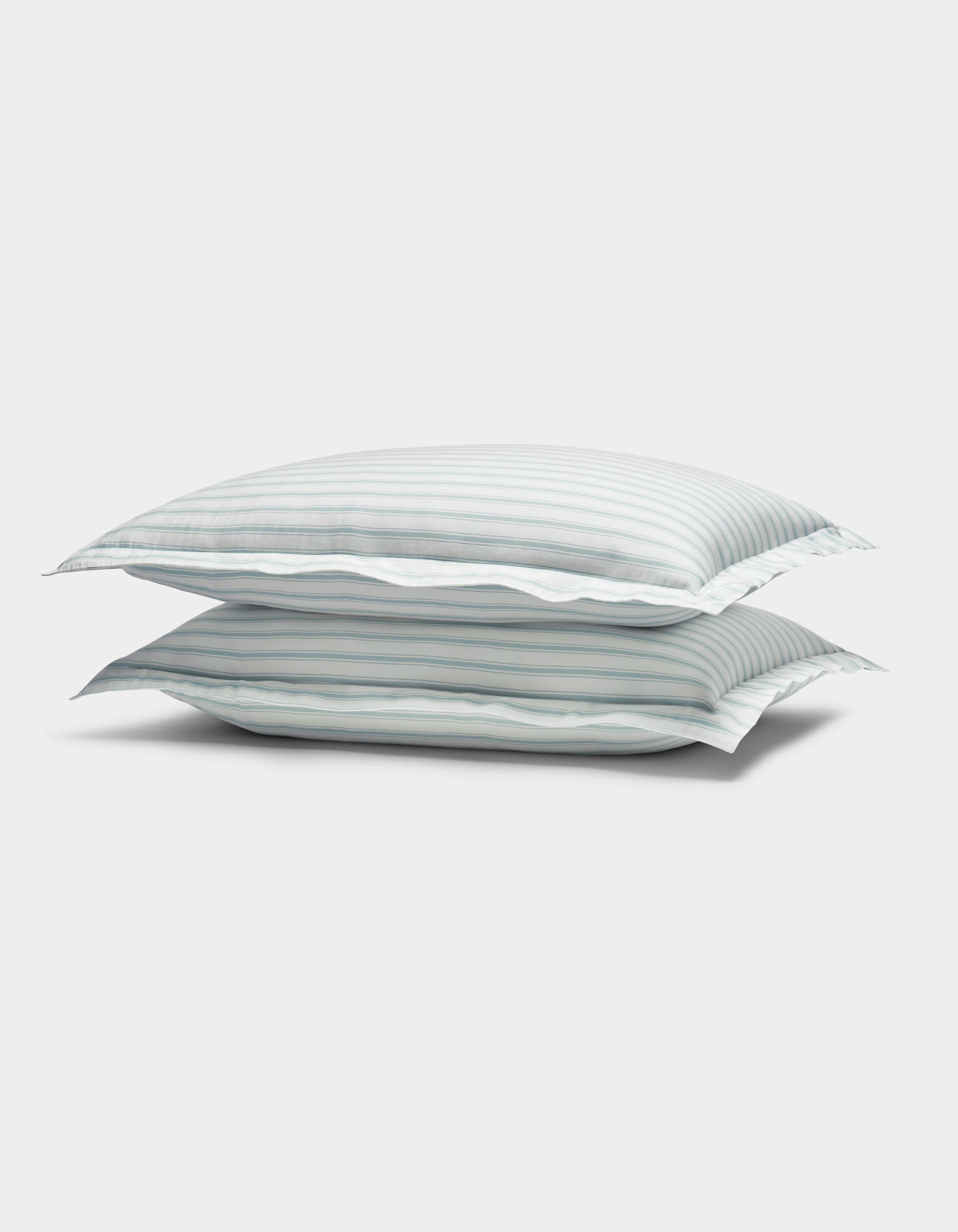 The image shows two Soft-Wash Cotton Shams by Cozy Earth, featuring light blue and white horizontal stripes, stacked against a plain white background.|Color:River and Sea Salt Stripe