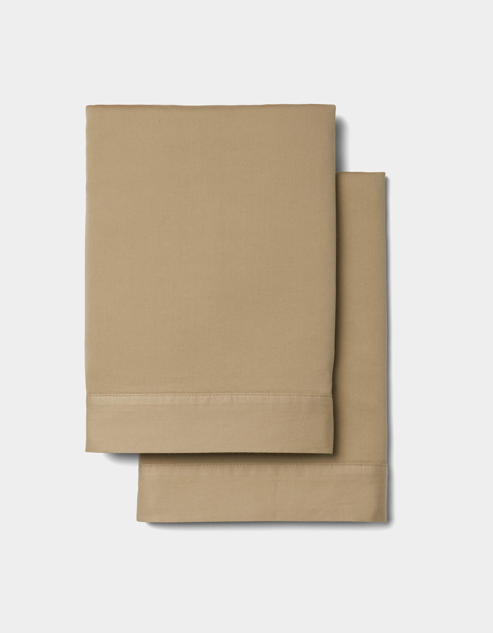 Two neatly folded Cozy Earth Soft-Wash Cotton Duvet Sets, in beige, are stacked on a plain white background. The sets feature a smooth texture and seam detailing along the edges.