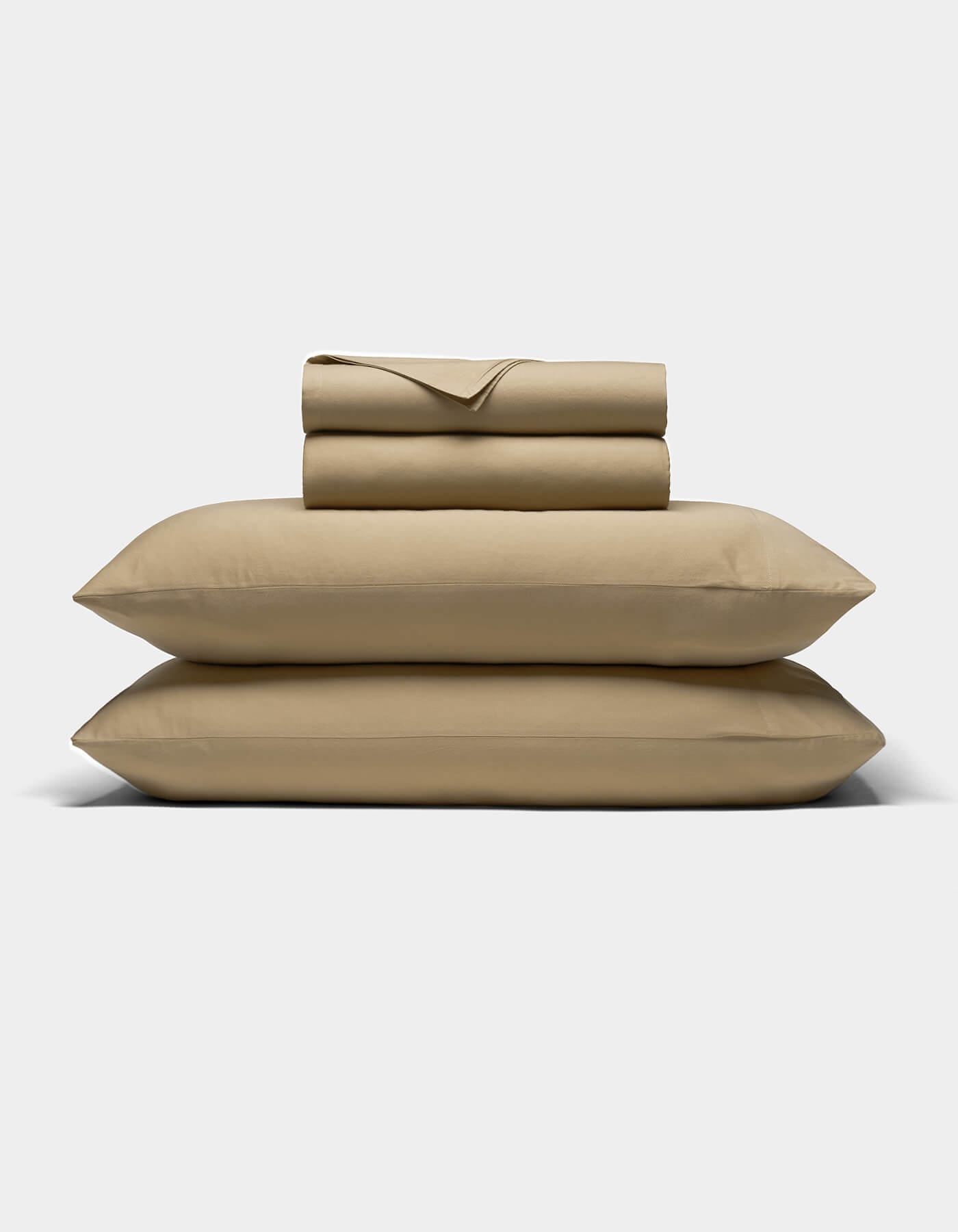 The Cozy Earth Soft-Wash Cotton Sheet Set, featuring two pillowcases, a flat sheet, and a fitted sheet in beige, is neatly folded and stacked on a light gray background.|Color:Sandalwood