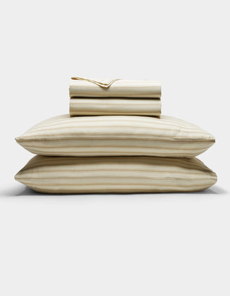 The Cozy Earth Soft-Wash Cotton Sheet Set in beige and light brown stripes is neatly stacked with two pillows at the base, topped with folded sheets and a pillowcase, displayed against a plain white background.|Color:Coconut and Sandalwood Stripe