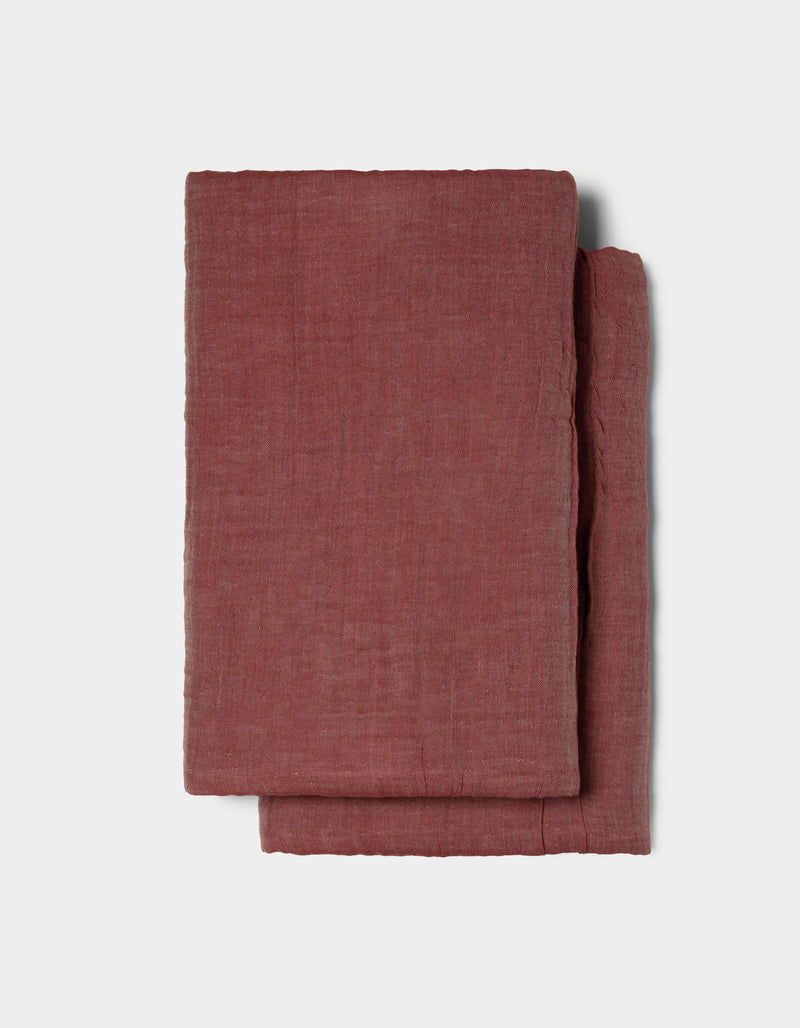 The Cozy Earth Waterfront Shams, featuring a folded, textured reddish-brown fabric, are displayed on a plain light gray background.