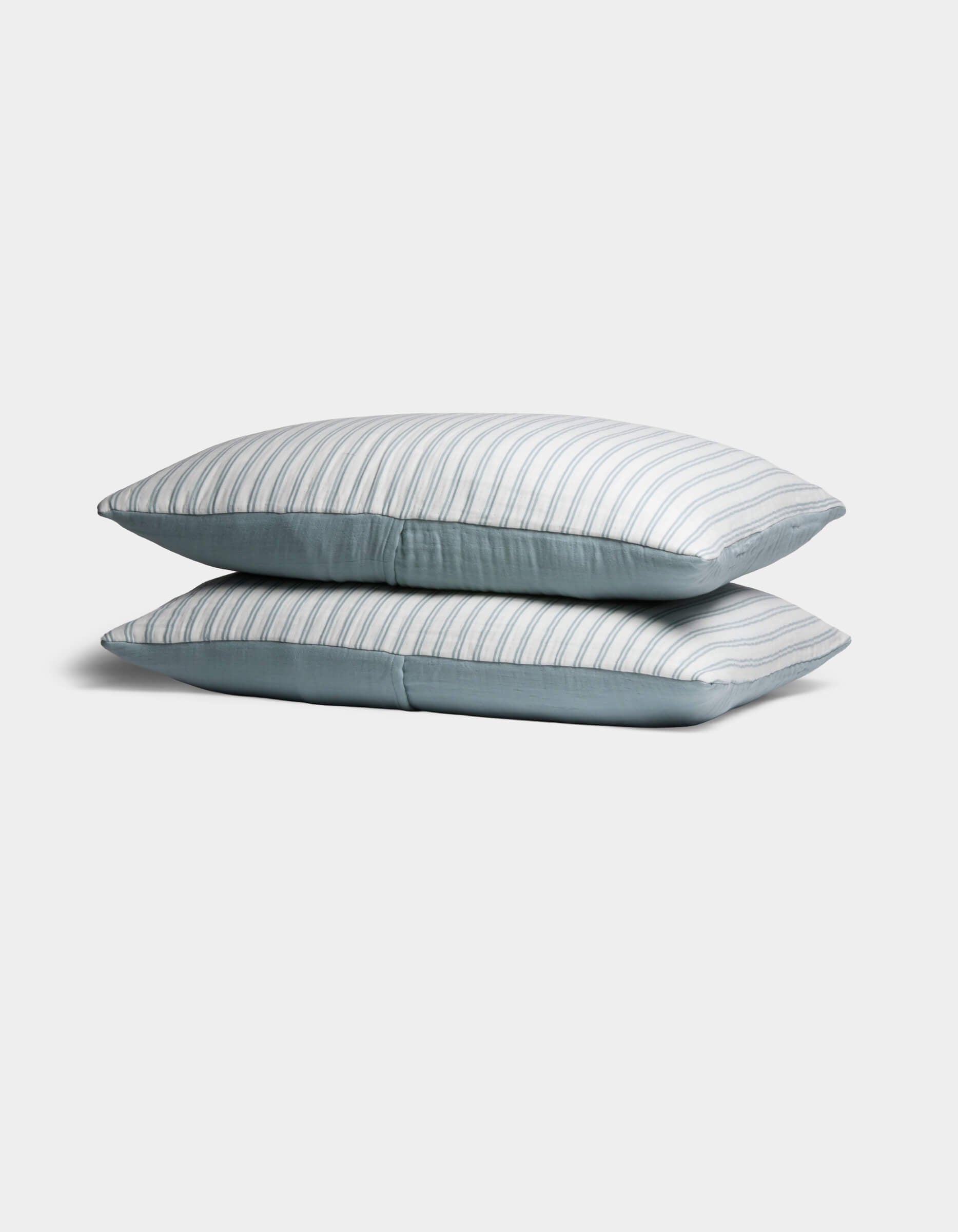 Two Cozy Earth Waterfront Shams are stacked neatly, featuring light blue and white stripes, against a plain white background.|Color:River Stripe