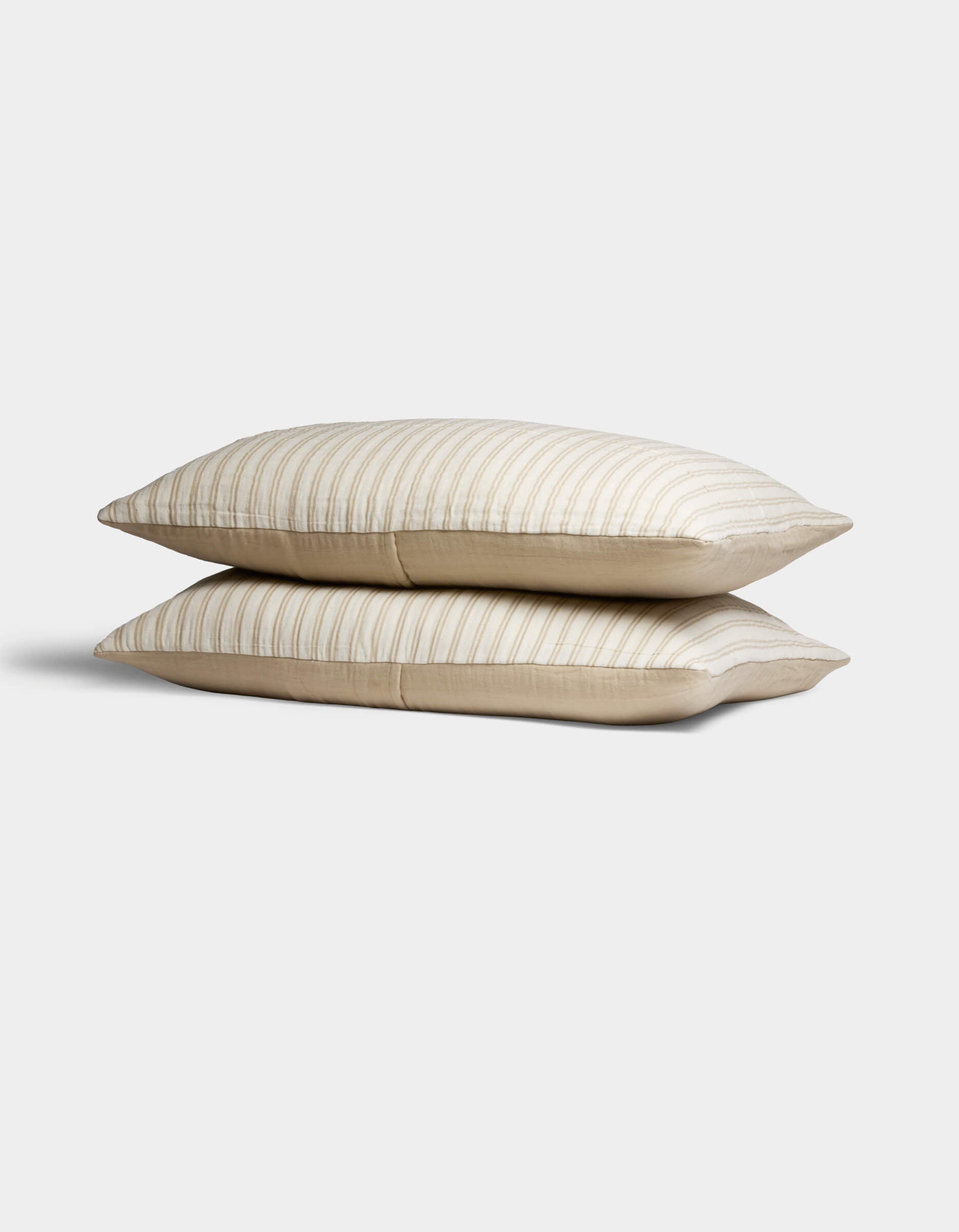 Two Cozy Earth Waterfront Shams in beige, featuring subtle horizontal stripes, are stacked against a plain white background.|Color:Sandalwood Stripe