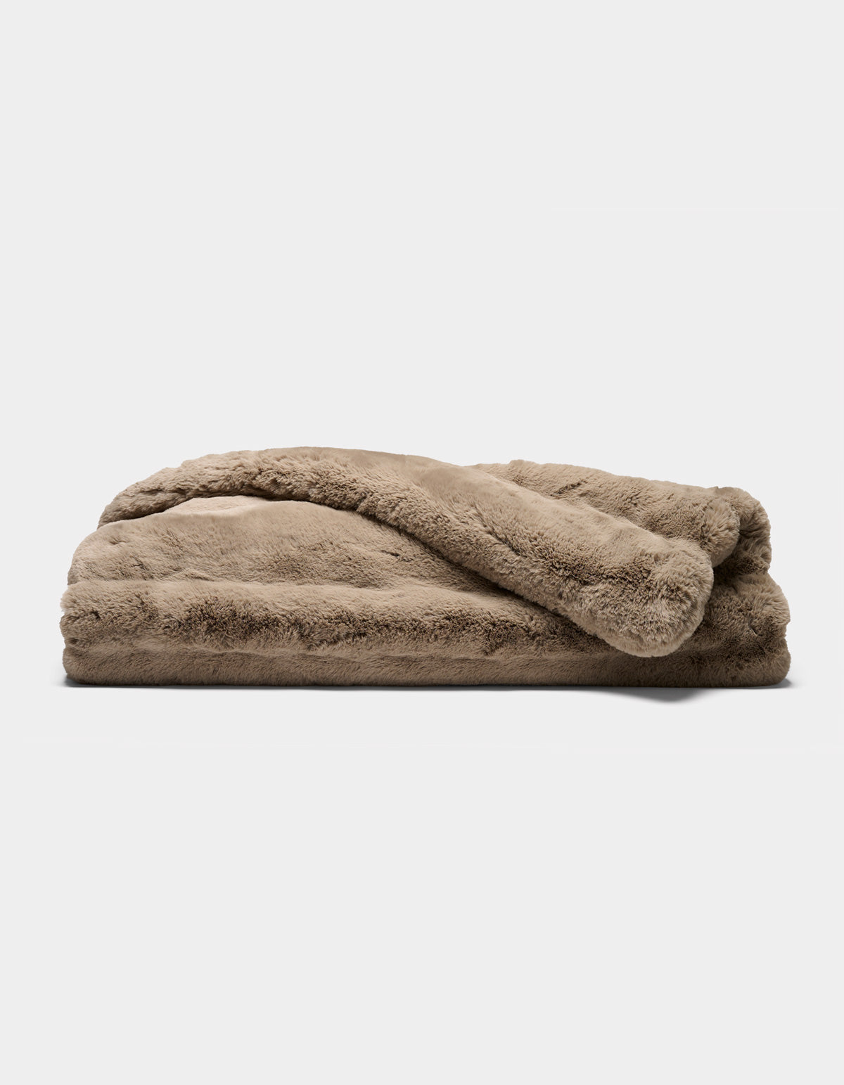 A folded Channel Cuddle Blanket by Cozy Earth, featuring a plush, light brown color and soft, fuzzy texture, resting on a plain white background.