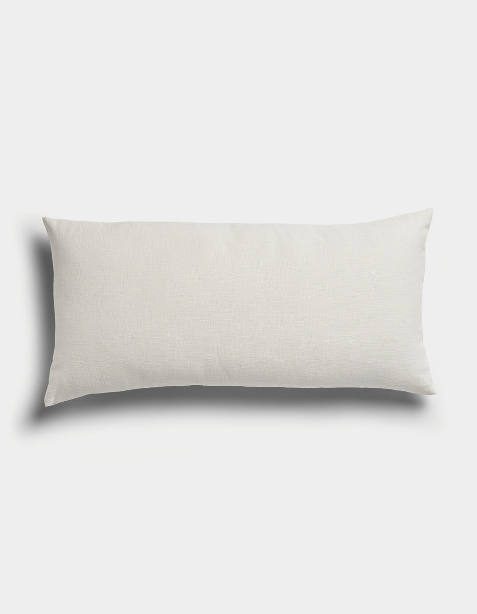 The Sonoma Throw Pillow by Cozy Earth, featuring a rectangular, white design, is displayed on a plain white background with soft shadows on the left and bottom sides.|Color:Sea Salt|Size:14" x 30"