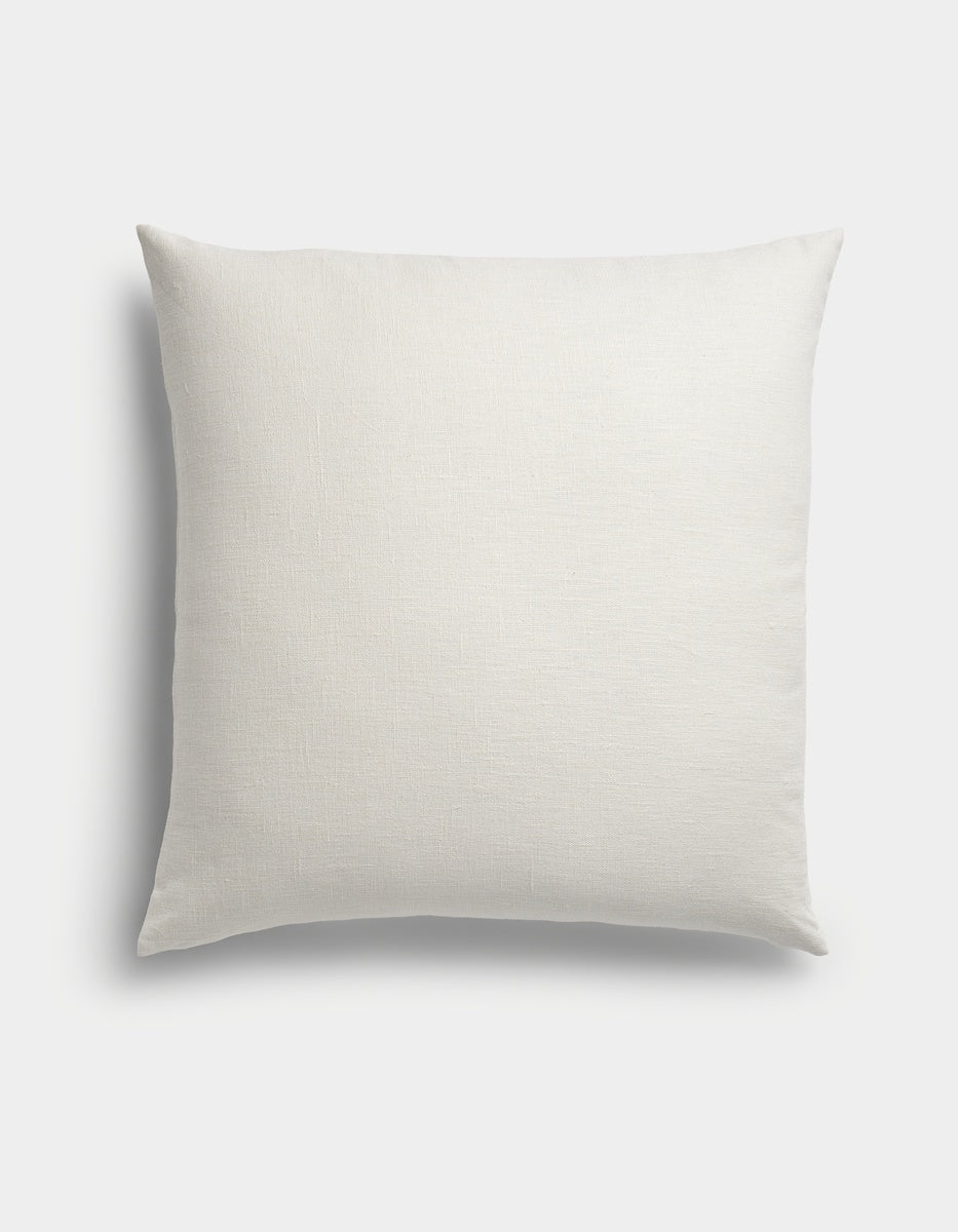 The Sonoma Throw Pillow by Cozy Earth, featuring a square shape and smooth, plain white fabric, is displayed against a light background in an overhead shot.
