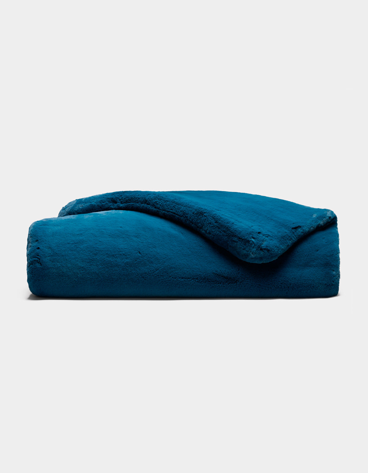 The Cozy Earth Superplush Cuddle Blanket is neatly folded and showcased against a plain light gray background, with one corner gently flipped to reveal its soft, plush texture.|Color:Deep Water