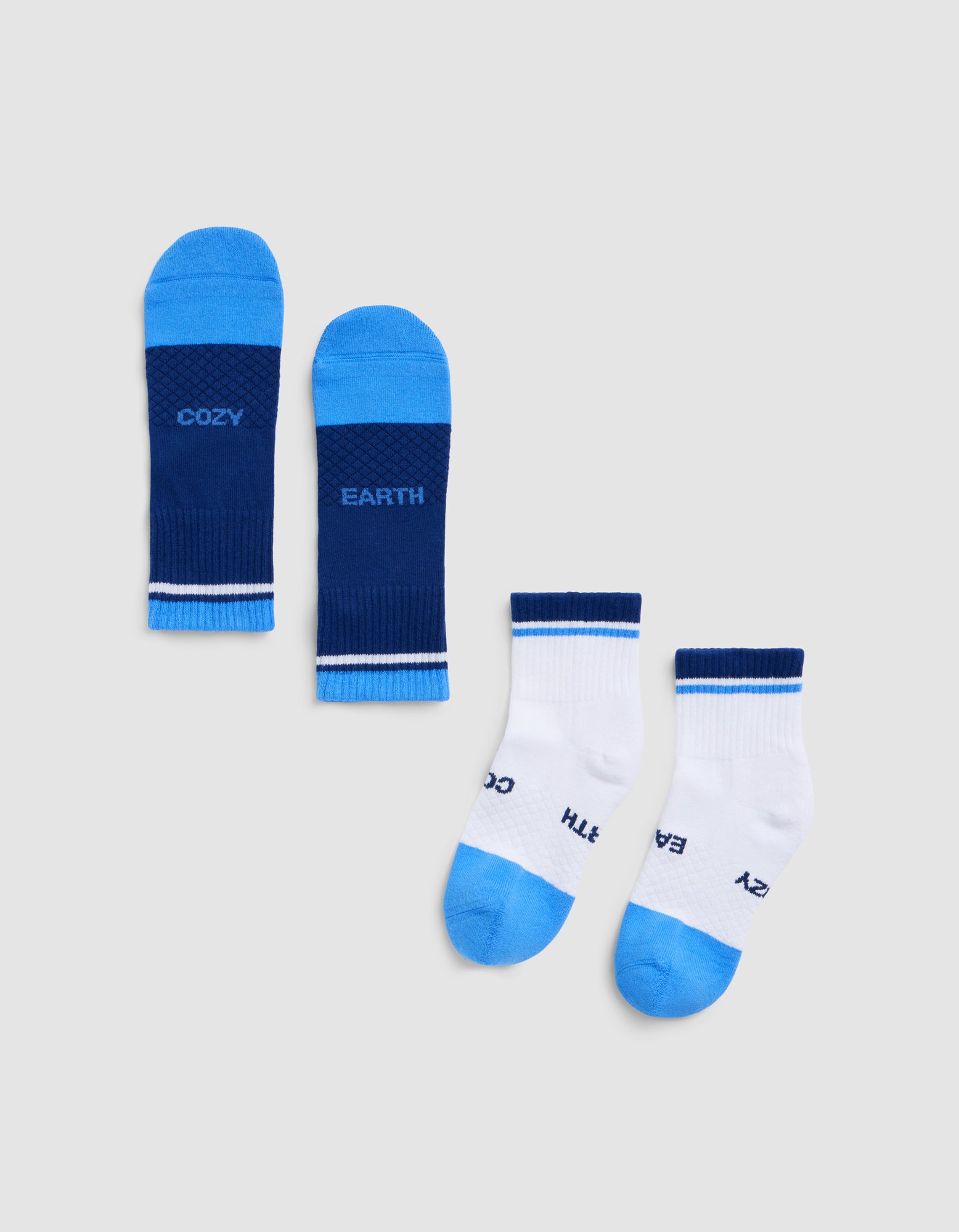 Two pairs of Cozy Earth Essential Quarter Socks are shown: one pair in dark blue with "COZY" and "EARTH" on the soles, and one pair in white with blue toes, heels, cuffs, and "COZY" and "EARTH" on the soles.|Color:Harbor