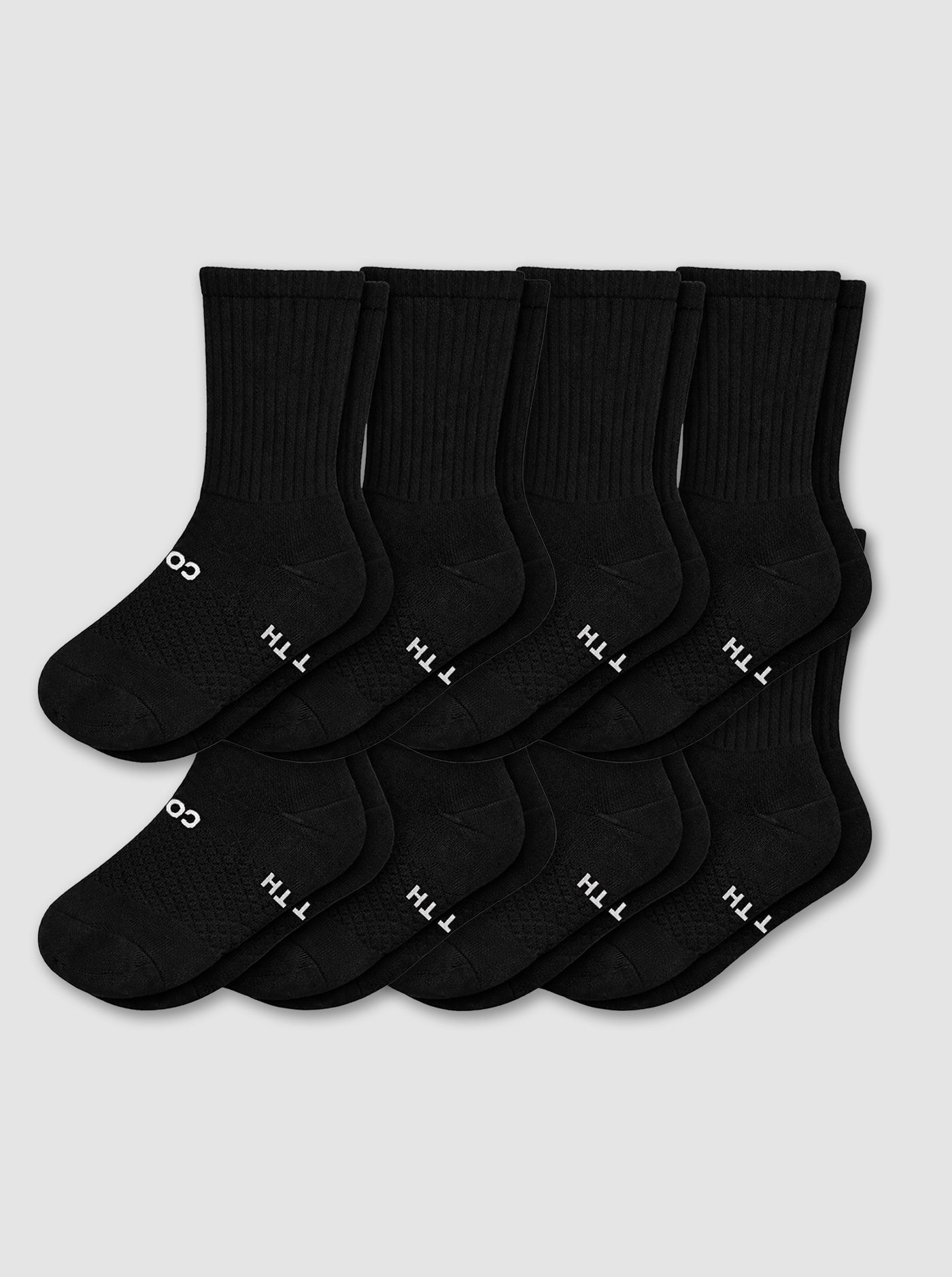 Eight pairs from the Cozy Earth Men's Essential Calf Sock 8-Pack in black are displayed in two neat overlapping rows on a light gray background, each featuring small white text and symbols near the toes.|Color:Black