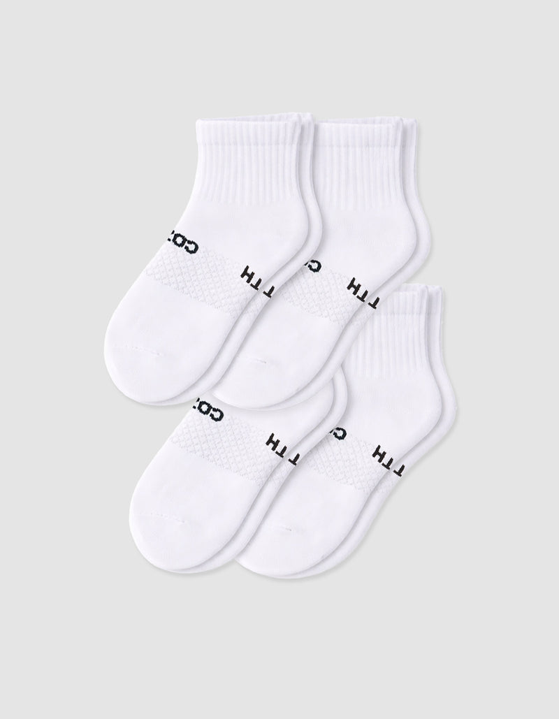 Four pairs of Cozy Earth Women's Essential Quarter Socks in white, featuring ribbed cuffs and black text, are arranged overlapping on a plain light background.