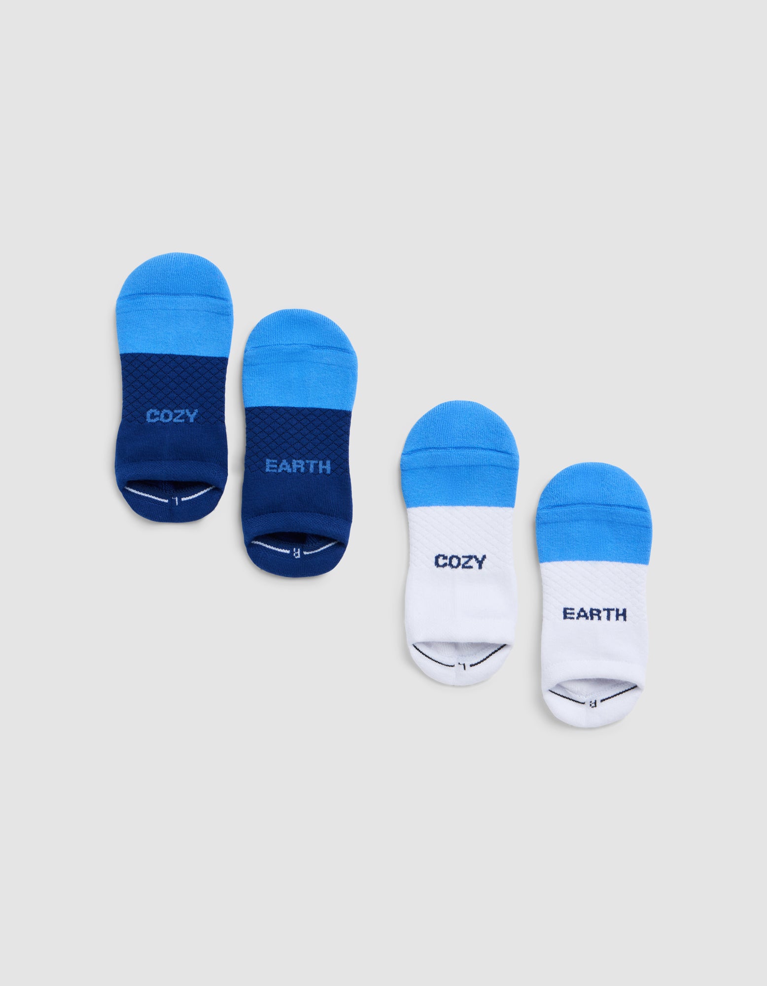 Two pairs of Cozy Earth Essential Ankle Socks—one dark blue, one white with light blue—each with "COZY" on the left and "EARTH" on the right, are displayed on a light gray background. |Color:Harbor