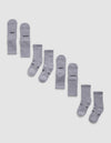 Eight pairs of Cozy Earth Essential Calf Socks, shown side by side in light gray on a white background, display both top and bottom views. Some socks feature black text near the cuffs and toes.|Color:Stone
