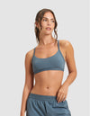 A woman with wavy brown hair in a ponytail wears the Cozy Earth Women's First Layer Pajama Soft Bra and matching shorts, looking to the side against a plain light gray background.|Color:Dawn