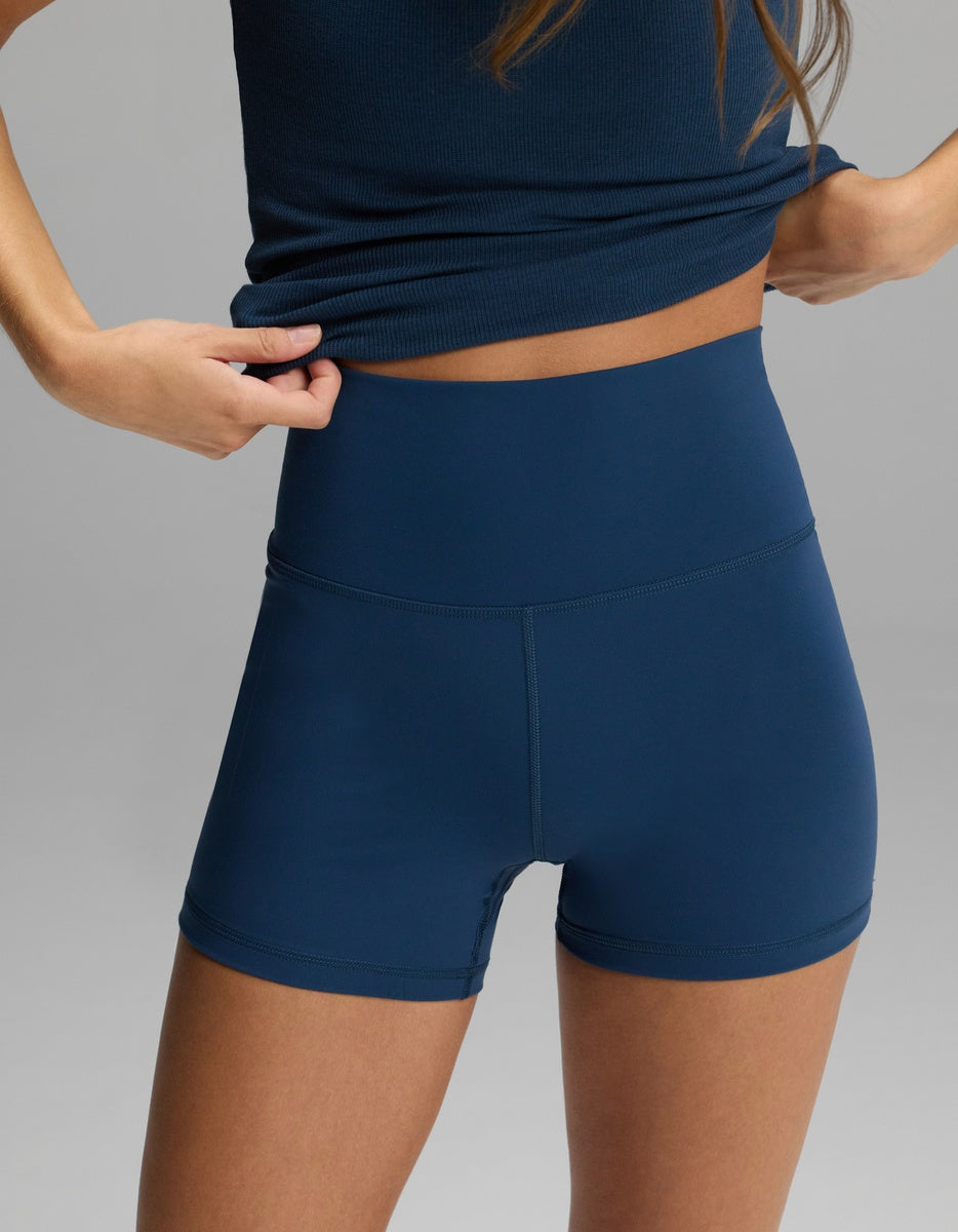A person wearing dark blue, high-waisted Women’s Liv Biker Short 4″ by Cozy Earth.|Color:Obsidian