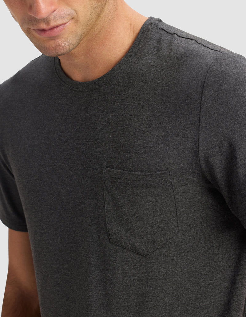 A man wears the Cozy Earth Men's Bamboo Stretch-Knit Lounge Tee in charcoal gray with a chest pocket, shown from shoulders to mid-torso against a light gray background. His face is partially visible.