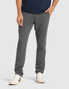 A person wears Cozy Earth Men's Everywhere Pant with white sneakers featuring black details, against a plain light background. Only the lower half is visible, with one hand in a pocket. |Color:Coal