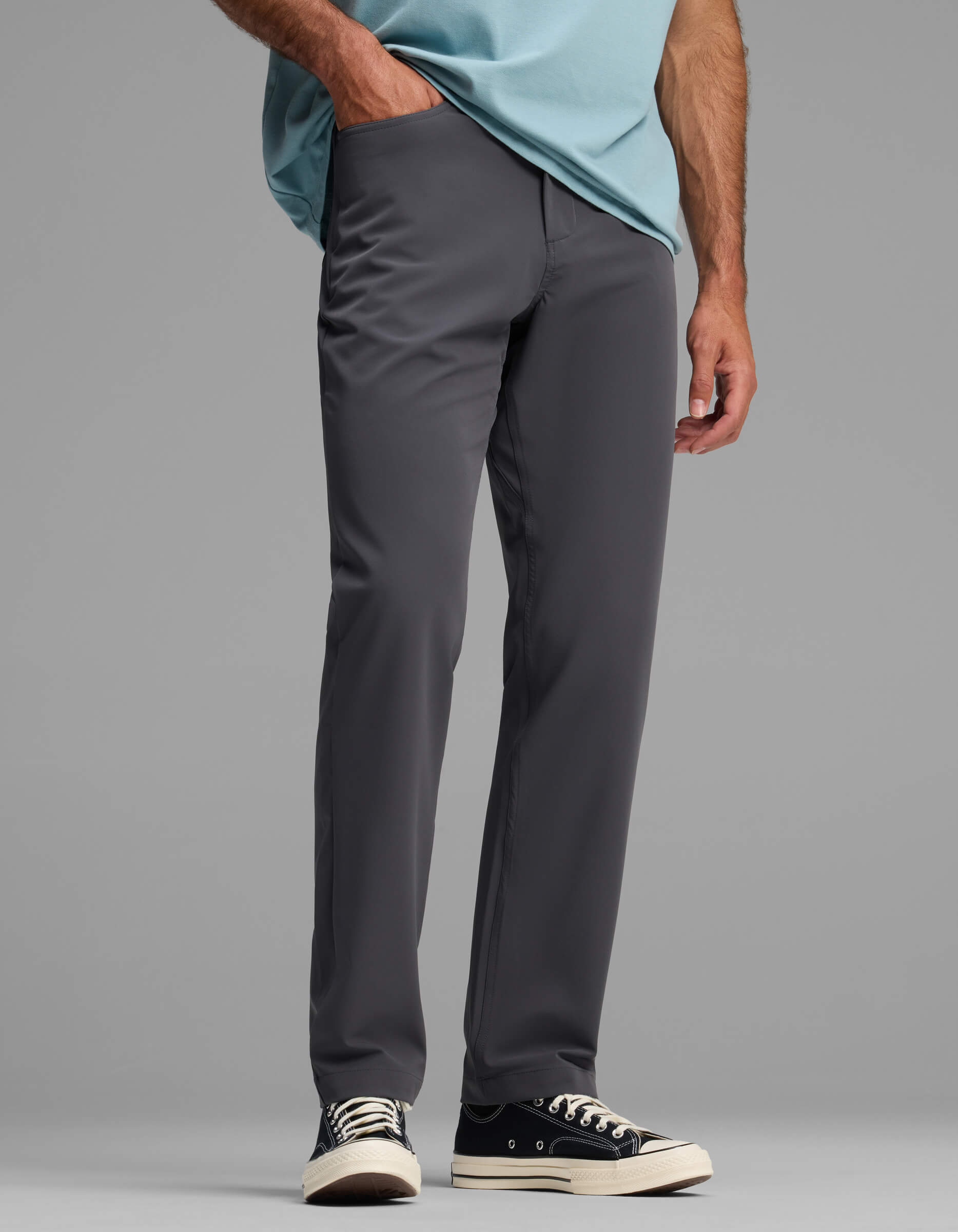 A person stands against a plain gray background, wearing only the Men's Everywhere Pant - Relaxed Fit by Cozy Earth, visible from the waist down.|Color:Graphite