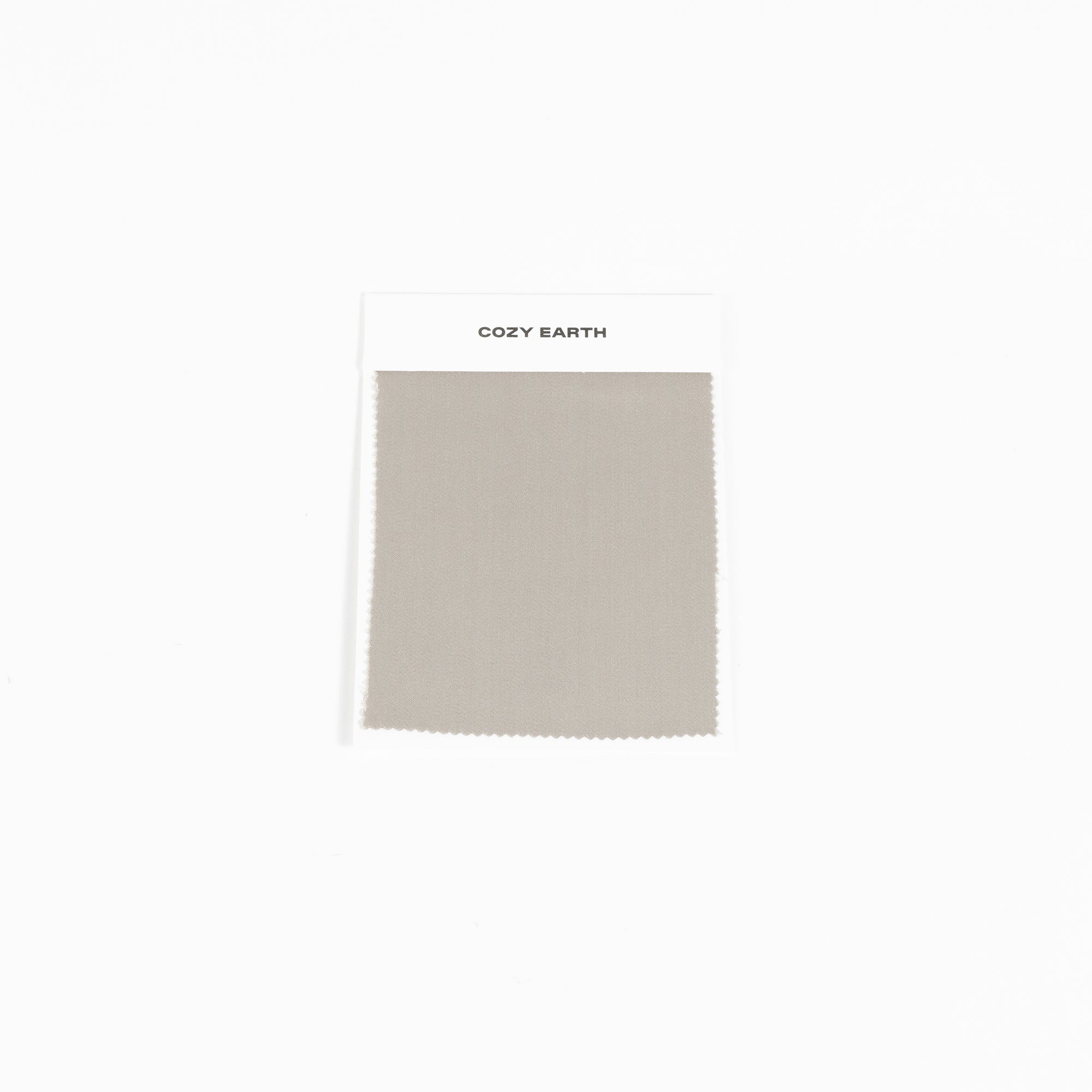 A swatch from the Bamboo Sheet collection by Cozy Earth is shown against a white background. It features a white label at the top with the brand name, "COZY EARTH. 