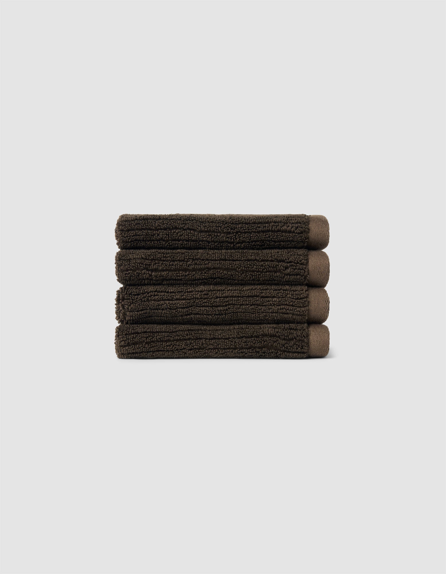 The Cozy Earth Complete Ribbed Terry Bath Bundle, featuring four dark brown towels, is arranged horizontally against a plain light gray background.|Color:Espresso