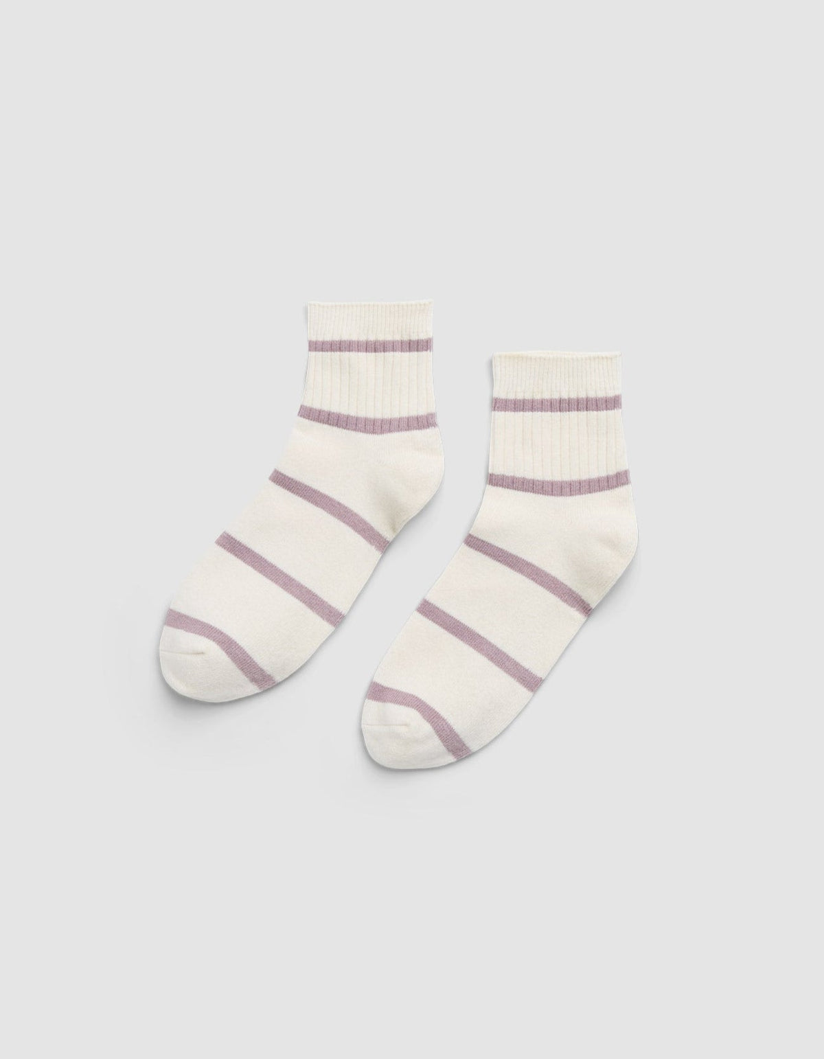 The Women's Sadie Sock by Cozy Earth is a pair of white ankle socks featuring light purple horizontal stripes and ribbed cuffs, displayed flat on a light gray background. |Color:Parchment/Dusty Orchid