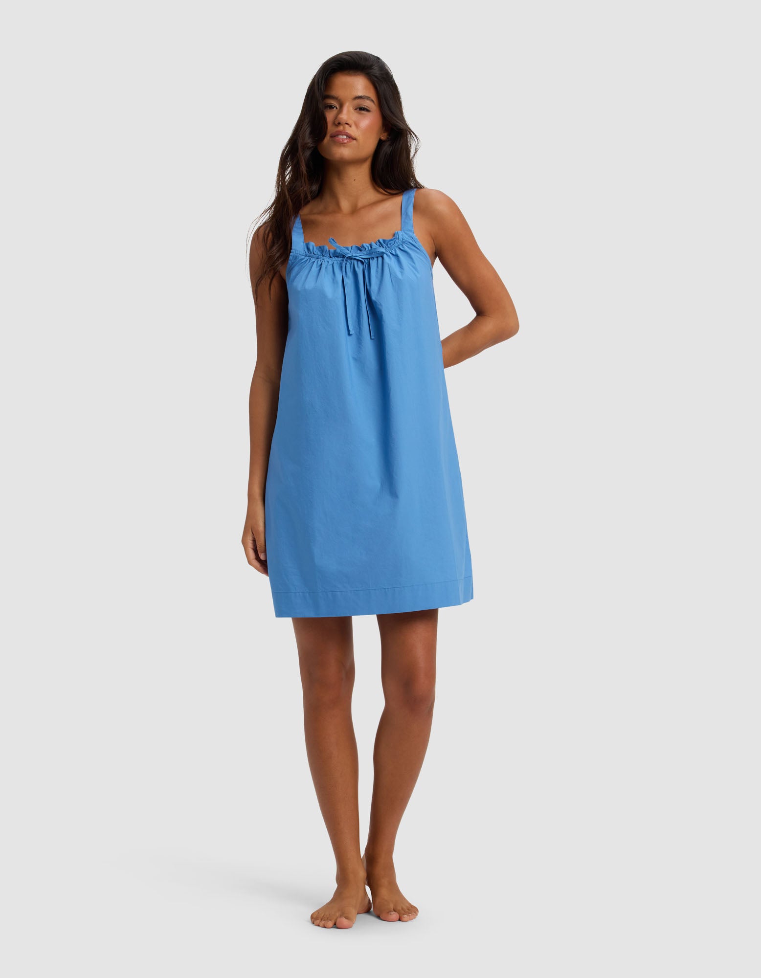 A woman stands barefoot against a plain background, wearing the Cozy Earth Women's Sutton Tank Sleep Dress in Sailor—a loose-fitting, sleeveless style with gathered neckline detail and thin shoulder straps.|Color:Sailor
