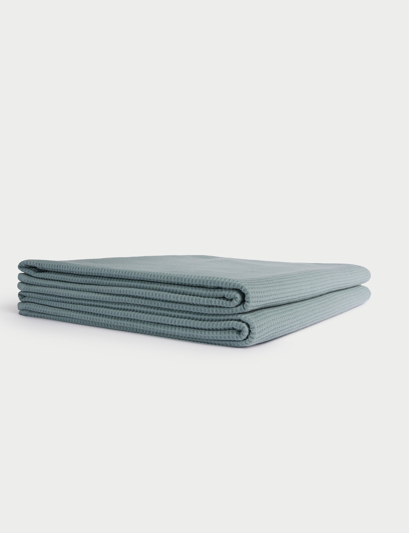A neatly folded, light blue Cozy Earth Waffle Bath Towel is displayed on a white background. |Color:Brook
