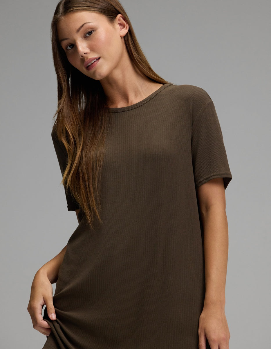 A woman with long brown hair stands against a plain gray background, wearing the Cozy Earth Women’s Bamboo Rib-Knit Boyfriend Sleep Dress.|Color:Espresso