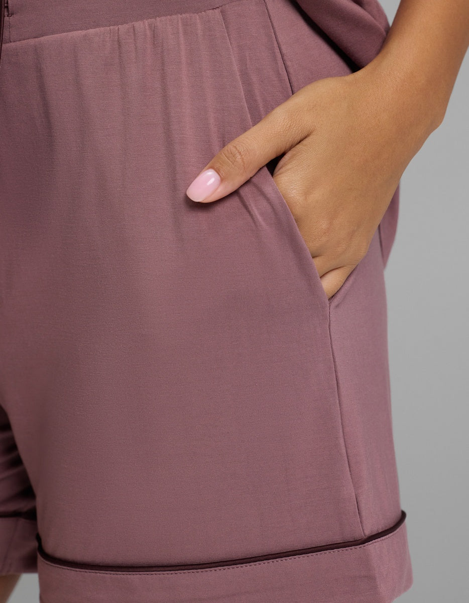 A hand rests in the side pocket of Women’s Bamboo Stretch-Knit Pajama Short in mauve with dark piping along the hem.