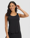 A woman with long, wavy dark hair smiles and poses in Cozy Earth's Women's Bamboo Stretch-Knit Tank & Short Set, featuring a sleeveless black tank top and matching shorts, against a plain light background.|Color:Black