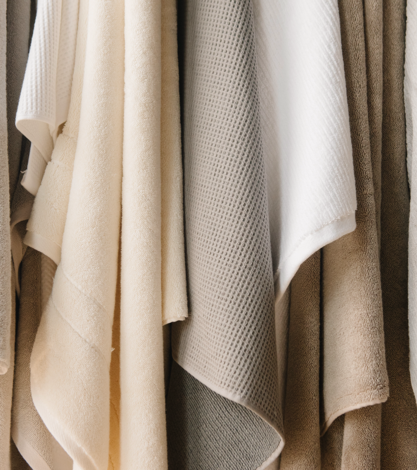 assortment of bath towels handing on a wall
