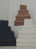 Video featuring Clay Dusk and Seashell bath sheets resting on a bathroom floor