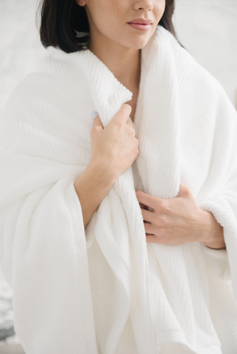 Ribbed Terry Bath Sheet in the color White. Photo of Ribbed Terry Bath Sheet taken with a woman who is wrapped in the Ribbed Terry Bath Sheet.