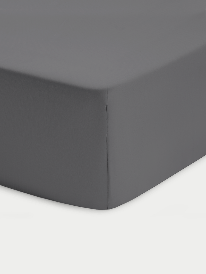 Corner of charcoal crib sheet with white background